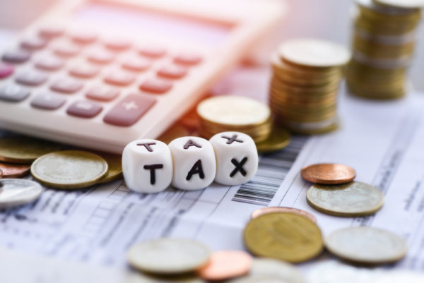 tax-words-calculator-stacked-coins-invoice-bill-paper-time-tax-filling uae corporate tax